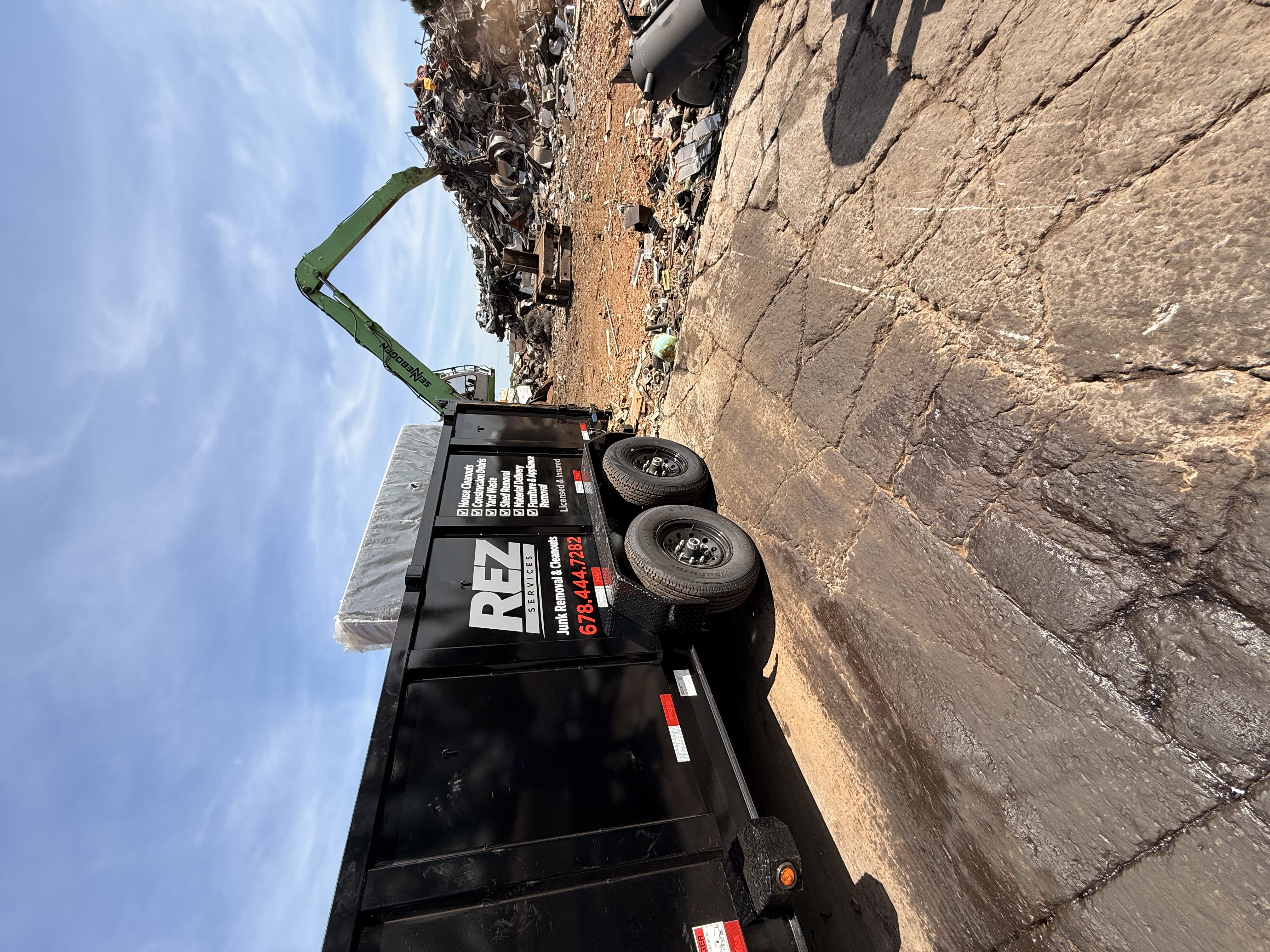 REZ Services trailer loaded with construction debris at a scrap yard